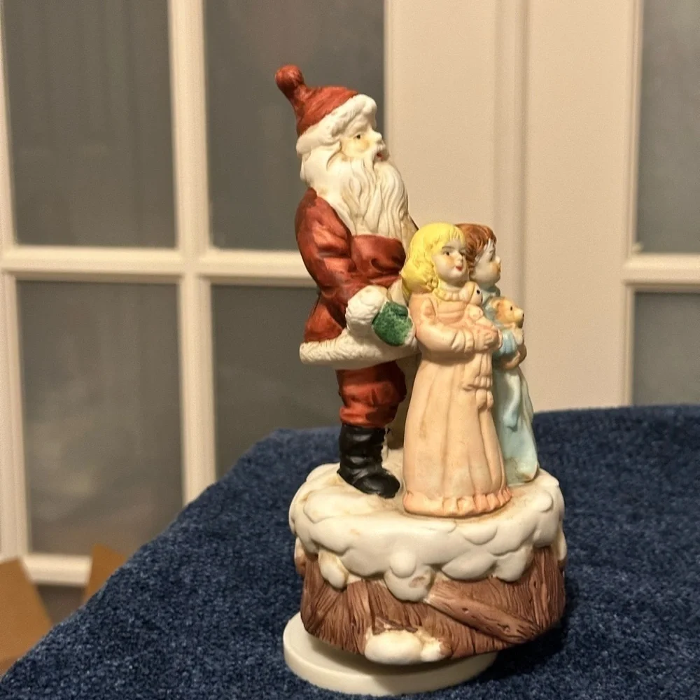 Beautiful Santa hugs 2 small children and plays Santa Claus is Coming to Town.